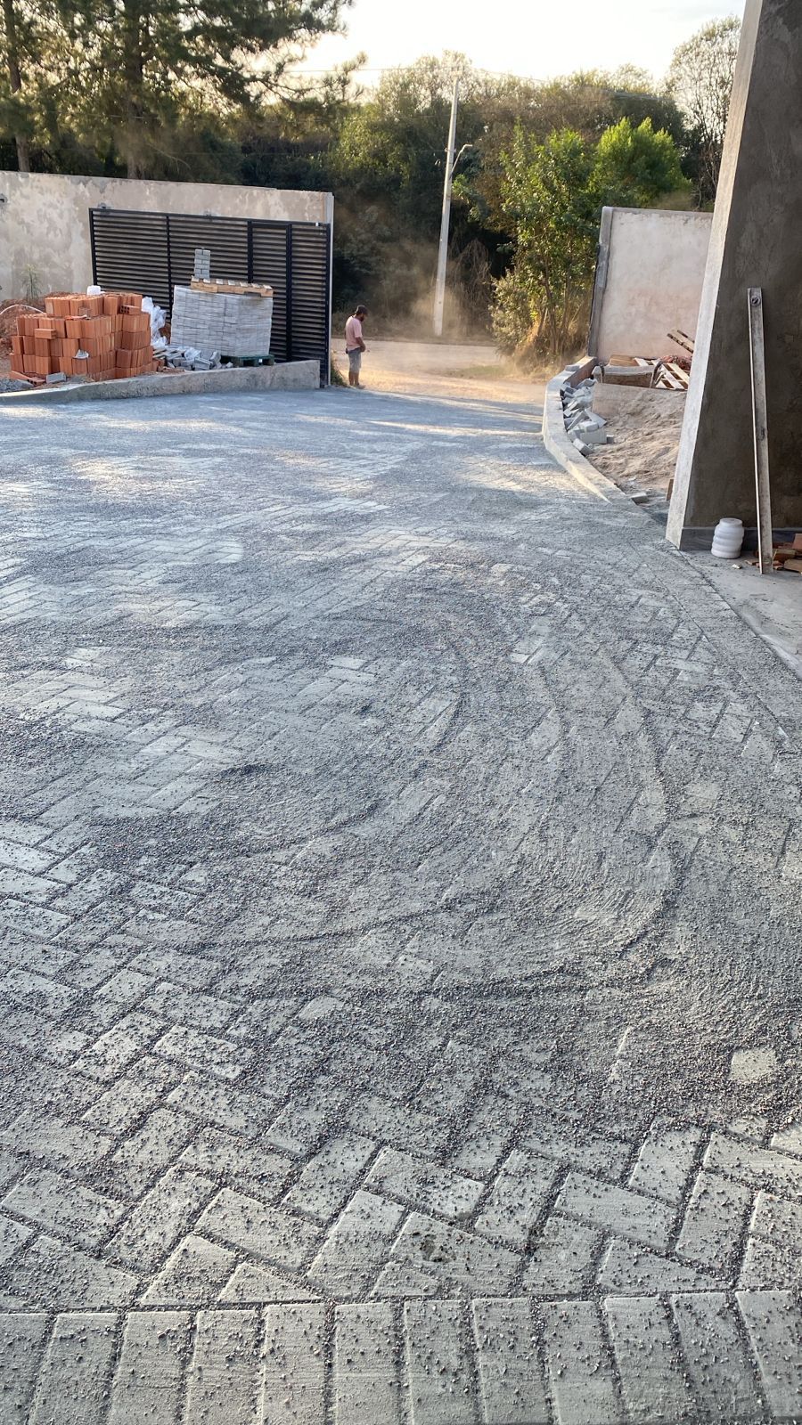 Área de paver com assentamento de areia, com trabalhador ao fundo