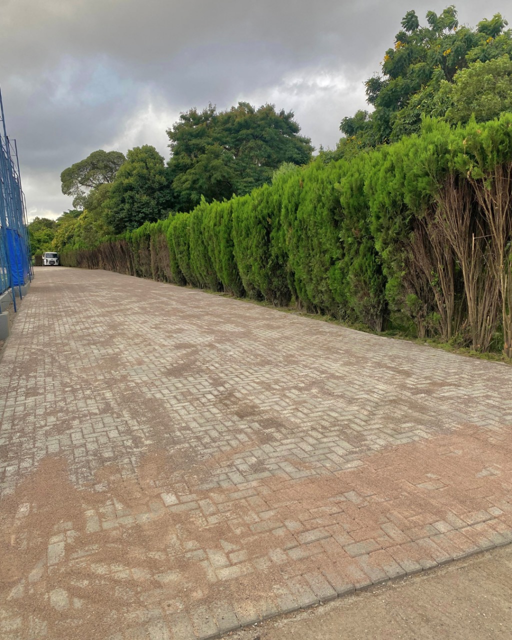 Longo corredor pavimentado em bloco de concreto de cor avermelhada